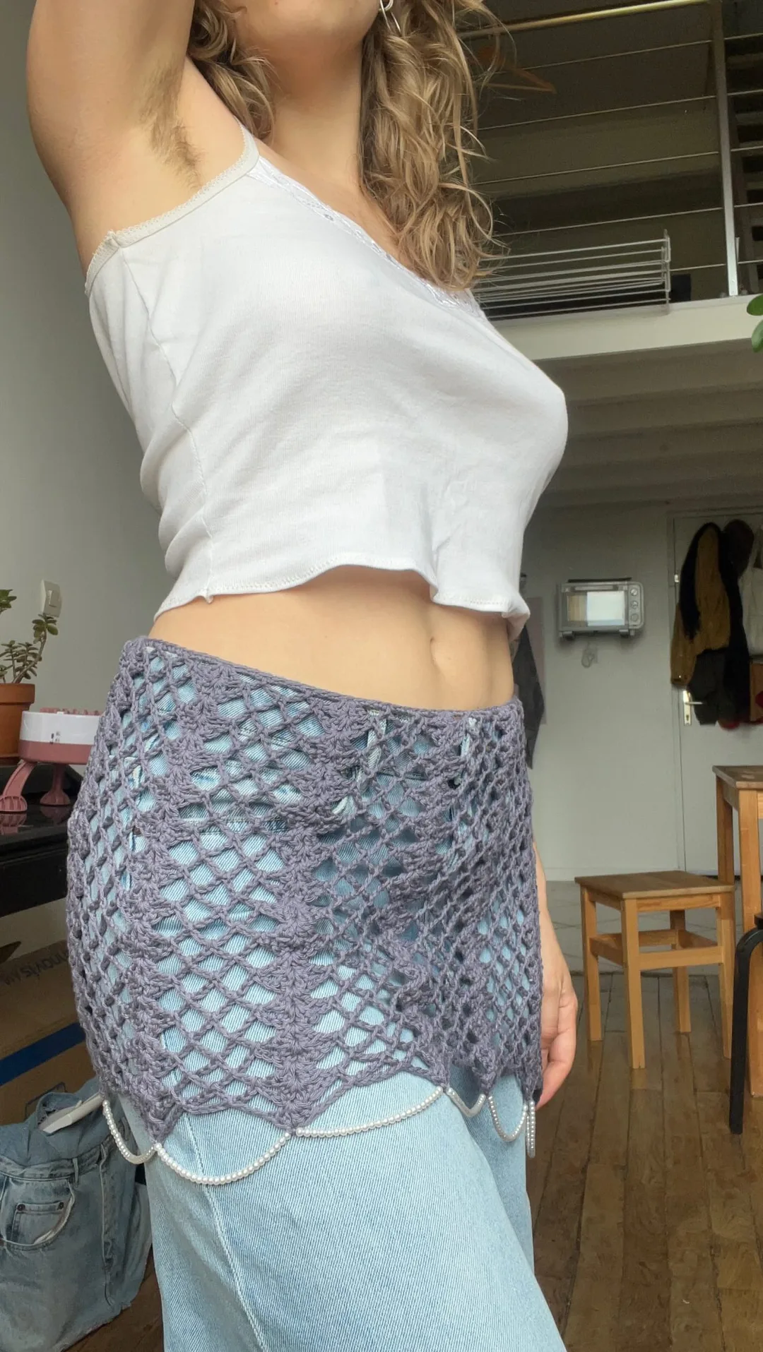 Surjupette en résille de crochet bleue portée sur un pantalon